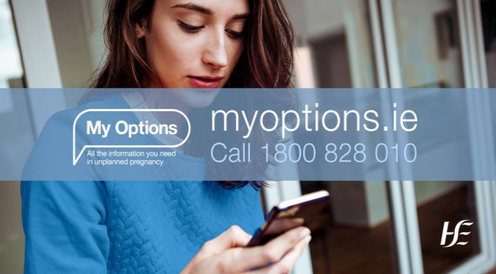 My Options social media graphic with contact details for the new website myoptions.ie and Freephone number 1800 828 010. Background photo shows a woman using her smartphone