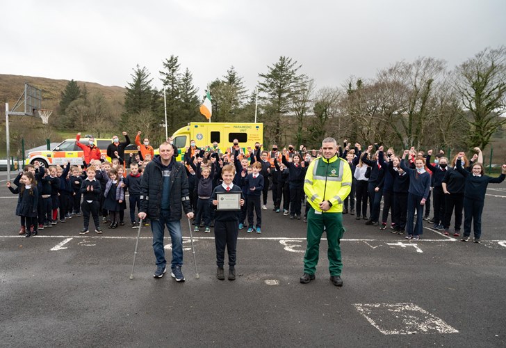 Owen Cunningham being presented with his award by the HSE National Ambulance Service outside of his National School, Scoil Chartha Naofa, Kilcar, Donegal