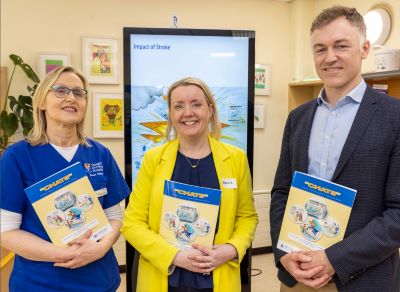 3 members of the team are standing in a row holding the new CHATS booklet