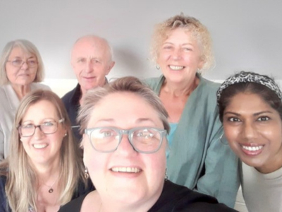 Five women and one man looking at the camera and smiling.
