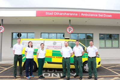 6 members of the National Ambulance Service Galway Pathfinder team standing in front of an ambulance. The ambulance is parked in an ambulance loading bay.