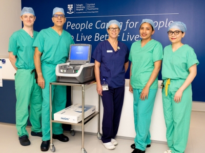 Five healthcare workers wearing medical scrubs in a healthcare setting.