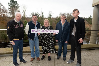 At the self advocacy learning event in Donegal, individuals accessing disability services stand in a group holding a  self advocacy  banner