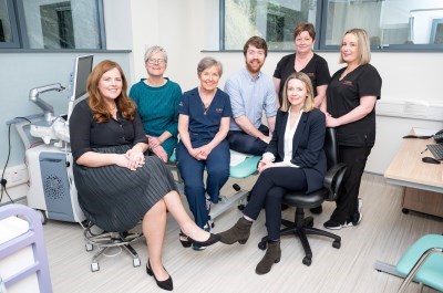 Large group of people in a clinical setting. 