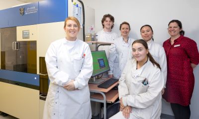 Group of lab healthcare staff standing around a computer. 
