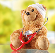 A teddy bear with a bandage around its head and a stethoscope around its body.