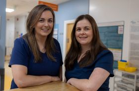 Two nurses in a clinical setting.