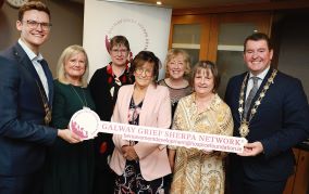 Group of people pictured with the Mayor of Galway city at the launch of New Bereavement Support Initiative in Galway. They are holding a sign that reads, Galway Grief Sherpa Network.