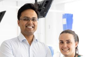 A man and woman indoors in a clinical setting.