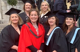 Group of nurse graduates in their caps and gowns at their graduation ceremony.