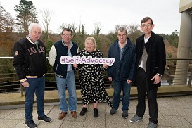 At the self advocacy learning event in Donegal, individuals accessing disability services stand in a group holding a "self advocacy" banner